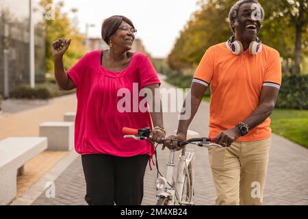 Glückliches Seniorenpaar, das zusammen Fahrrad fährt Stockfoto