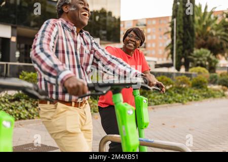 Glückliches Seniorenpaar, das seine Freizeit mit einem Scooter verbringt Stockfoto