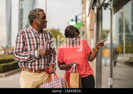 Seniorin, die mit einem Mann Schaufensterbummel macht Stockfoto