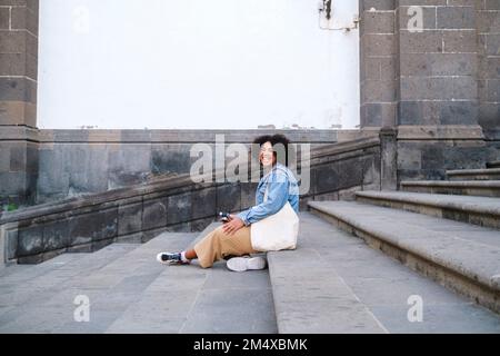 Glückliche junge Frau auf der Treppe Stockfoto