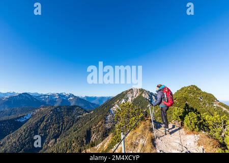 Deutschland, Bayern, weibliche Wanderer, die die umliegende Landschaft vom Gipfel des Heimgartens bewundern Stockfoto