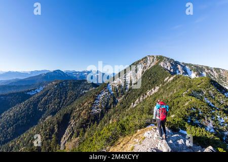 Deutschland, Bayern, weibliche Wanderer, die die umliegende Landschaft vom Gipfel des Heimgartens bewundern Stockfoto