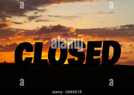 Die Inschrift ist vor dem Hintergrund eines hellen Sonnenuntergangs geschlossen. Closing- und Care-Konzept. Stockfoto