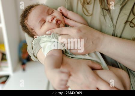 Mutter berührt Wangen und verwöhnt kleine Mädchen zu Hause Stockfoto