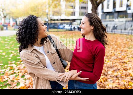 Fröhliche multirassische Frauen, die Spaß im Park haben Stockfoto