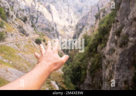 Spanien, Kastilien und Leon, Posada de Valdeon, Persönliche Perspektive des Menschen, der in das Bergtal hineinreicht, im Hintergrund gesehen Stockfoto