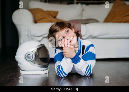 Ein nachdenkliches lächelndes Mädchen, das zu Hause am Helm liegt Stockfoto