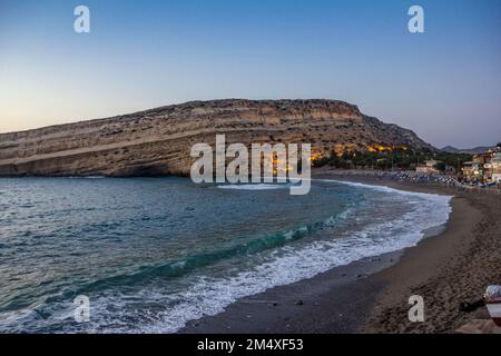 Griechenland, Kreta, Matala, Matala Beach und Höhlen an den Klippen in der Dämmerung Stockfoto