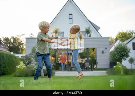 Glückliches Mädchen und Junge spielen im Garten Stockfoto