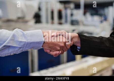 Geschäftsmann, der Kollegen in der Industrie die Hand schüttelt Stockfoto