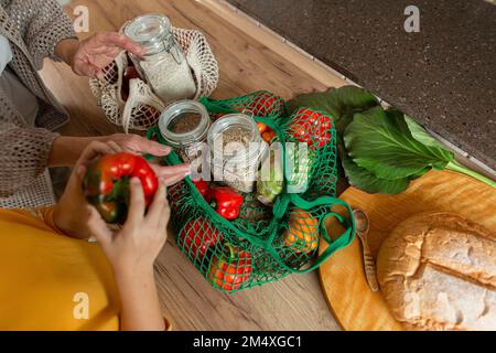 Großmutter und Enkelin packen frische Lebensmittel in der Küche aus Stockfoto