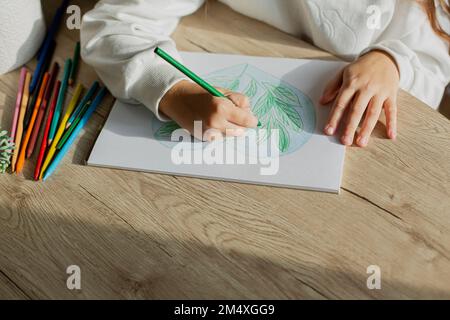 Ein Mädchen, das am Tisch ein Bild zeichnet Stockfoto