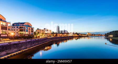Deutschland, Sachsen-Anhalt, Magdeburg, Panoramablick auf moderne Apartments entlang der Elbe mit Magdeburger Dom im Hintergrund Stockfoto