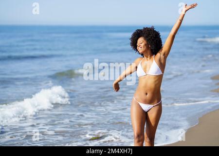 Eine sorgenfreie junge Frau, die Spaß am Strand hat Stockfoto