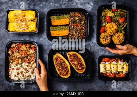 Studioaufnahme mit einer Vielzahl von Speisen zum Mitnehmen, einschließlich Chop Suey, gefüllte Kartoffeln, Fajitas, Reismuffins, Ricotta Brötchen, Verschiedene Salate und Terrine Stockfoto