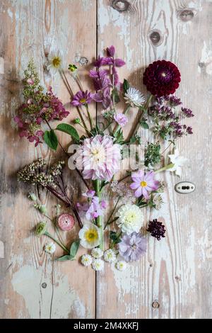 Verschiedene Blumen flach auf Holzfläche gelegt Stockfoto