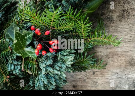 Ein Teil des Kranzes besteht aus Fichte, Wacholder, Efeu und Hagebutten Stockfoto