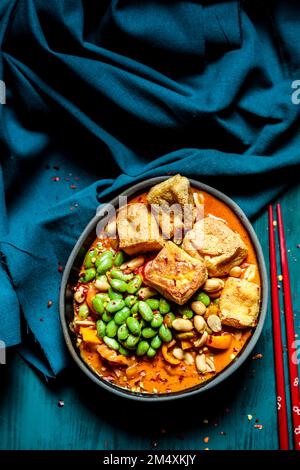 Schüssel mit verzehrfertigem veganem Curry mit Edamam und Tofu Stockfoto