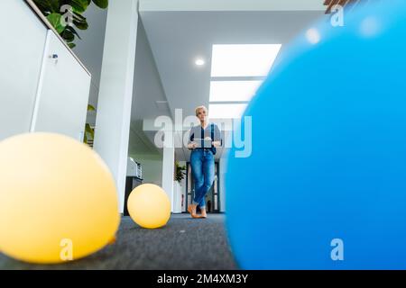 Geschäftsfrau, die einen Tablet-PC am Arbeitsplatz hält Stockfoto