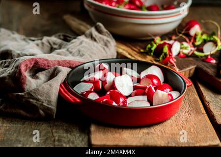 Rote Radieschen in Auflauf am Tisch Stockfoto