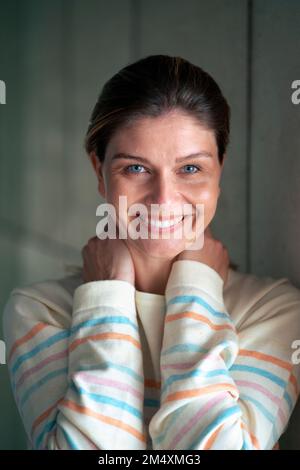Lächelnde, wunderschöne junge Frau in gestreifter Kleidung Stockfoto