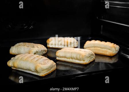 Fünf Brötchen mit Schinken, Käsebacken im Elektroofen Stockfoto