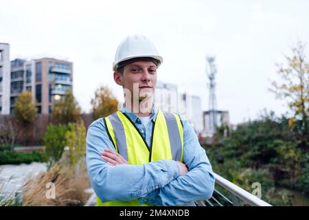 Selbstbewusster junger Ingenieur mit verschränkten Armen Stockfoto