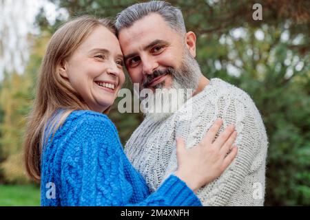 Glückliches Paar, das Pullover trägt und sich umarmt Stockfoto