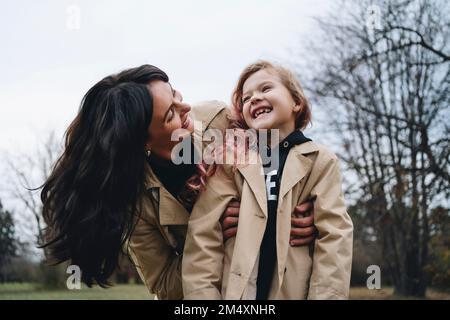 Glückliche Mutter, die Spaß mit der Tochter im Park hat Stockfoto
