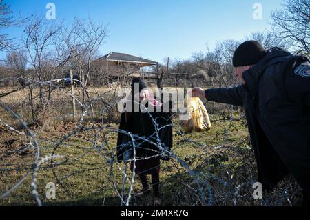 KHURVALETI, GEORGIEN - DEZEMBER 23 - Polizeiwache gibt Nahrung an Valia Valishvili (90), die seit 2008, als Russland erfolgreich war, auf dem besetzten Gebiet lebt Stockfoto