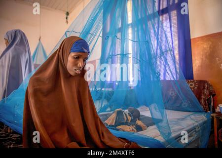 Mogadischu, Somalia. 19. Dezember 2022. Fadumo Manur sitzt neben ihrem zweijährigen Sohn auf der Station zur Stabilisierung der Unterernährung des Bay Regional Hospital, Baidoa. Das Horn von Afrika leidet unter seiner schlimmsten Dürre seit Jahrzehnten, wobei Millionen Somalier Nahrungsmittel, Hilfe und humanitäre Hilfe benötigen. (Foto: Sally Hayden/SOPA Images/Sipa USA) Guthaben: SIPA USA/Alamy Live News Stockfoto