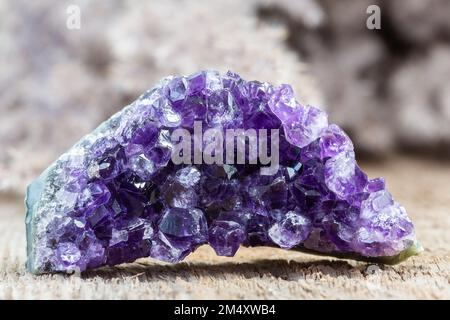 Purple Amethyst Crystal Druzy Cluster mit Holzhintergrund. Das Heilkristall-Konzept Amethyst ist gut, um Angst und Stress zu lindern. Natürliche Minera Stockfoto