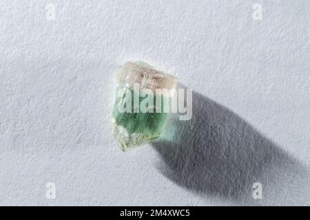 Rohrosa und grüne Wassermelone, Tourmalinkristall auf weißem Hintergrund in rauem Licht Stockfoto