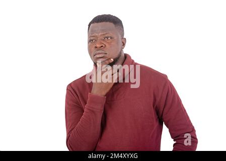 Porträt eines gutaussehenden jungen Mannes, der denkt, während er Hand am Kinn hält. Stockfoto