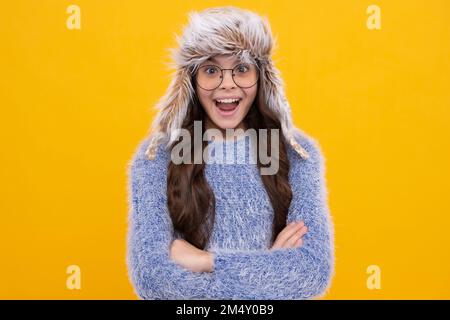 Schulmädchen in Winterkleidung und warmen Hut. Winterurlaub. Modelmodell für Kinder. Aufgeregt Gesicht, fröhliche Emotionen von Teenager-Mädchen. Stockfoto