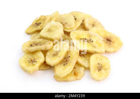 Haufen getrockneter Bananen auf weißem Hintergrund. Süße Snacks, getrocknete Bananenscheiben. Organische getrocknete Bananenchips aus der Nähe. Stockfoto