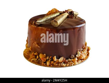 Schokoladenkuchen-Isolat. Schokoladenkuchen mit goldenen Stöcken und zerdrückten Nüssen. Eine Portion Kuchen für Tee, die zu Hause zubereitet wird. Stockfoto