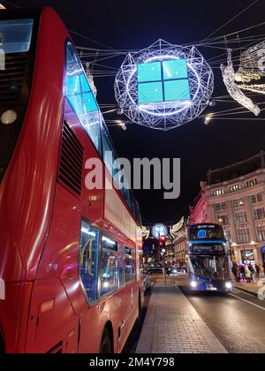 London Bus und Spirits of Christmas alias Angels über der Regent Street als Teil der Weihnachtsbeleuchtung. Nach London Stockfoto