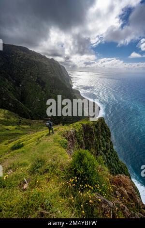 Touristen stehen auf einer Klippe, Blick auf Klippen und Meer, Küstenlandschaft, Aussichtspunkt Ponta da Leideira, nahe Calhau das Achadas, Madeira Stockfoto