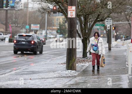 Seattle, Washington, USA. 23. Dezember 2022. Ein Fußgänger manövriert einen gefrorenen Bürgersteig entlang des Fauntleroy Way in West Seattle, während ein Eissturm den Westen Washingtons umhüllt. Kredit: Paul Christian Gordon/Alamy Live News Stockfoto