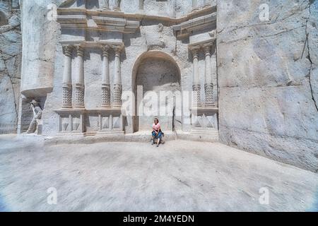 Frau sitzt am berühmten Tor der Aschenbeerstraße (ruta del sillar) in Arequipa in Peru. Stockfoto