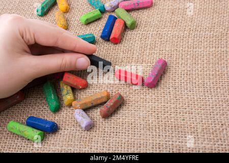 Benutzte Farbstifte und eine Hand, die einen hielt Stockfoto