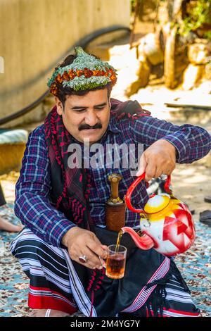 Traditionell gekleideter Mann des Qahtani-Blumenstammes, serviert Tee, Asir-Berge, Königreich Saudi-Arabien Stockfoto