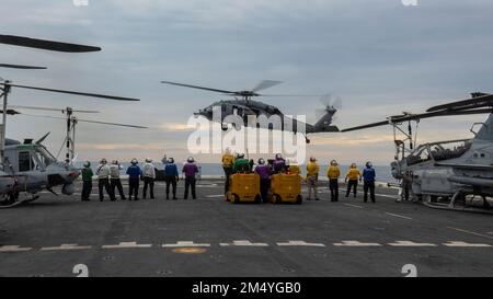 PAZIFIK (17. DEZEMBER 2022) – USA Marines bei der 13. Marine Expeditionary Unit und U.S. Marinesoldaten, die der Amphibienladerampe USS Anchorage (LPD 23) zugeteilt sind, führen Nachschub auf See durch, Dezember 17. Der 13. MEU ist eine Kraft der Bereitschaft, die darauf ausgerichtet ist, in allen Bereichen rasch auf Krisen zu reagieren. Die 13. Marineexpeditionstruppe wird auf die Makin Island Amphibious Ready Group aufgeladen, die aus dem Amphibienschiff USS Makin Island (LHD 8) und den Amphibienschiffen USS John P. Murtha (LPD 26) und dem Anchorage besteht. Und im US-Flottenbereich 7. tätig sind, um int Stockfoto