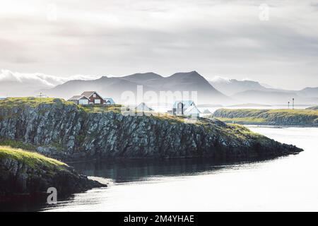 Nebel über dem Meer in der Stadt Stykkisholmskirkja in Island, farbenfrohe Häuser am Rand der Klippe Stockfoto