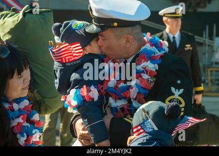 Yokosuka, Japan. 16. Dezember 2022. David Yaung, Senior Chief Culinary Specialist aus San Francisco, begrüßt seine Familie am Pier als die USA Der einzige in der Marine eingesetzte Flugzeugträger, USS Ronald Reagan (CVN 76), kehrt nach seinem Einsatz im westlichen Pazifik im Dezember zurück zu Commander, Fleet Activities Yokosuka, Japan. 16. Während des Einsatzes von Ronald Reagans führte das Schiff gemeinsame Übungen der Carrier Strike Group (CSG) mit der Republik Korea Navy durch, nahm an multinationalen Übungen mit der japanischen Seeschifffahrts-Selbstverteidigungskräfte und der Royal Australian Navy während der Valiant Sh Stockfoto