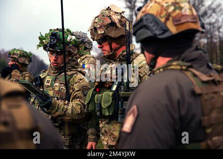 Grafenwoehr, Deutschland. 10. Dezember 2022. Führer der ungarischen und rumänischen Armee beobachten Soldaten, die dem 1. Bataillon, dem 26. Infanterie-Regiment, dem 2. Brigaden-Kampfteam und der 101. Luftwaffendivision (Luftangriff) zugeteilt wurden, während sie am 9. Dezember 2022 eine kombinierte Feuerübung (CAMLFEX) auf dem Trainingsgelände Grafenwoehr, Deutschland, durchführen. Unser Engagement für die Verteidigung des NATO-Territoriums ist unumstößlich, und die USA werden weiterhin unsere Haltung stärken, um unsere NATO-Verbündeten besser zu verteidigen. (Kreditbild: © Malcolm Cohens-Ashley/USA Armee/ZUMA Press Wire Service) Stockfoto