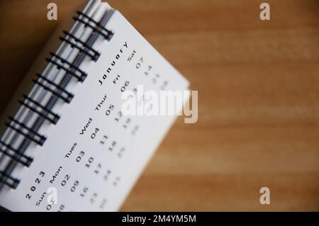 Februar 2023 weißer Tischkalender mit Tischhintergrund aus Holz. Konzept Kalender 2023. Stockfoto