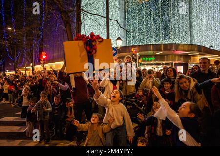 Bilbao, Spanien. 23. Dezember 2022. Kinder versuchen während der Olentzero Parade, die durch die Hauptstraßen von Bilbao führt, eine Geschenkbox zu fangen. Nach der Tradition verlässt der Olentzero sein Haus im Wald und bereitet sich darauf vor, in die Stadt zu fahren, damit alle Mädchen und Jungen ihm persönlich ihre Briefe bringen. Kredit: SOPA Images Limited/Alamy Live News Stockfoto