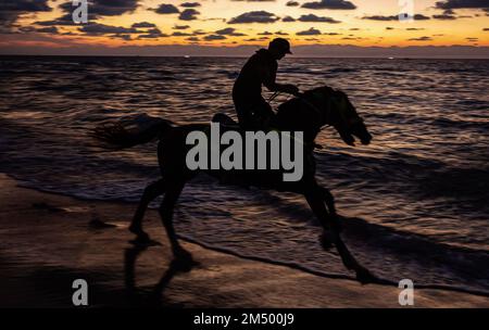 Gaza, Palästina. 24. Dezember 2022. Ein Palästinenser reitet sein Pferd am Ufer des Mittelmeers in Gaza City. (Foto: Yousef Masoud/SOPA Images/Sipa USA) Guthaben: SIPA USA/Alamy Live News Stockfoto